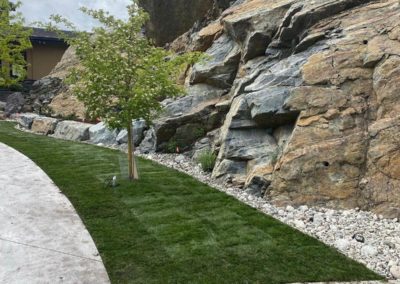Emerald After Sod placement next to large stone hill